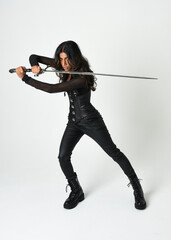 Fantasy female warrior in leather armour  full body studio portrait of fierce brunette in catsuit...