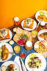 Rijk gedekte tafel met comfort food en bier