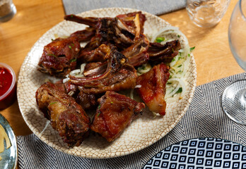 Delicious grilled lamb shashlik garnished with fresh onion slices served on white plate