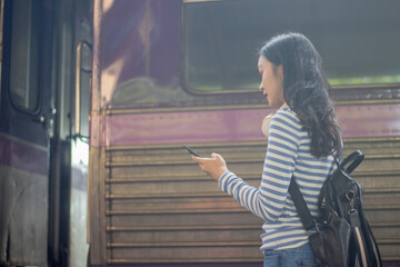 Confident businesswoman standing alone on a transit platform, holding a map and ticket, planning...