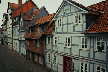 Traditional European street view with colorful half-timbered houses and red tiled roofs in a quiet, historic town.