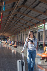 Confident businesswoman standing alone on a transit platform, holding a map and ticket, planning her journey in style, focus and anticipation.
