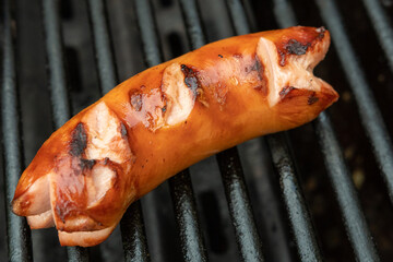 Gegrillter Cervelat mit eingeschnittenen Enden  auf dem Grill - Wurst