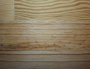 Wooden surface with horizontal grain showing a natural pattern with various shades of brown. Small...