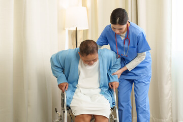Obraz premium Physiotherapist helps elderly patient stand from wheelchair, offering physical support and guidance, ensuring safety and encouraging confidence during the rehabilitation process.