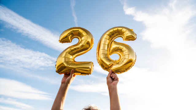 26th Birthday Celebration with Golden Foil Balloons Held by Hands Against Clear Blue Sky - Outdoor Party Festive Concept
