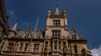 Majestic architecture of Gonville and Caius College, a constituent college of Cambridge University, displaying its intricate gothic revival style against a clear blue sky