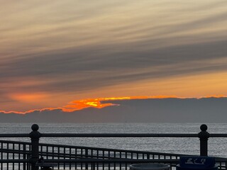 Obraz premium Close-up of vibrant sunrise sky bursting through clouds over the ocean at Virginia Beach
