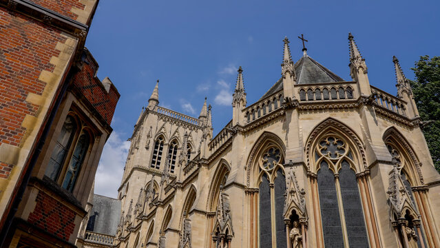 Architectural detail of St. John's College Chapel, a stunning example of the perpendicular gothic style, under a clear blue sky in Cambridge, UK