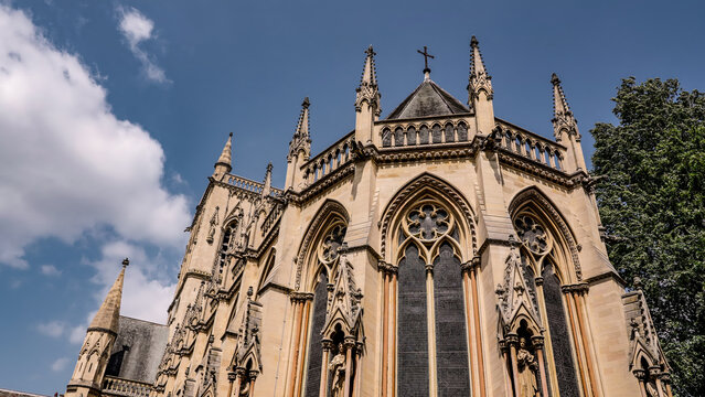 Architectural detail of St. John's College Chapel, a stunning example of the perpendicular gothic style, under a clear blue sky in Cambridge, UK