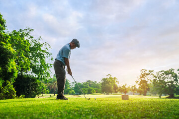 Senior Man Golfer Standing on Fairway with Focus to Hit Golf Ball During Morning Light for Active Retirement Lifestyle