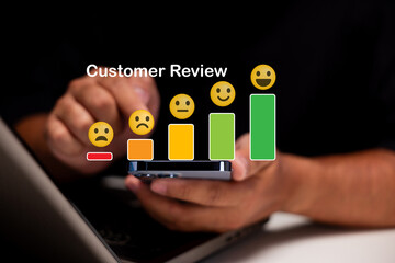 A person uses a smartphone to give a customer review, represented by a digital bar graph with emoticons from sad to happy on a dark background.