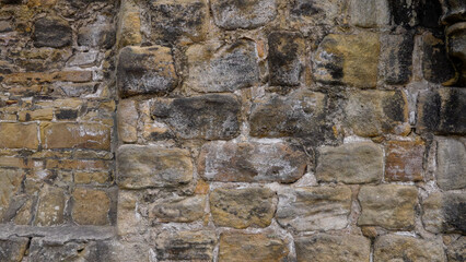 Weathered stone wall showing different colors and textures, perfect for backgrounds and creative projects