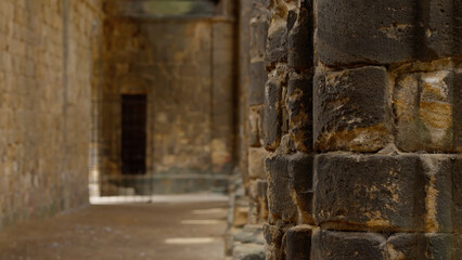 Close up of weathered stone blocks creating a passage towards a shadowy entrance, evoking mystery and antiquity