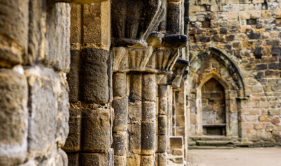 Architectural details showing weathered stone columns and arches in the ruins of Kirkstall Abbey, a cistercian monastery in Leeds, West Yorkshire, England