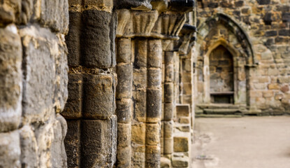 Perspective view of stone columns supporting ancient architecture inside Kirkstall Abbey, Leeds,...