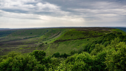 Lush green valley and hills stretching under cloudy sky in North York Moors National Park, United Kingdom