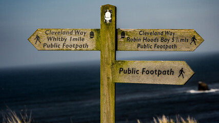 Wooden signpost showing Cleveland Way directions to Whitby and Robin Hoods Bay, North York Moors...
