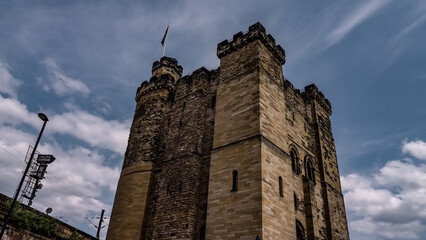 The imposing stone keep of Newcastle Castle stands tall against a backdrop of dramatic clouds, showcasing its historical architecture
