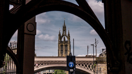 St. Nicholas Cathedral's tower rising majestically above the Tyne Bridge in Newcastle upon Tyne, UK, on a cloudy day
