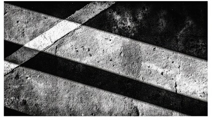 Monochromatic abstract of intersecting white lines cast in shadow on a textured, worn concrete surface