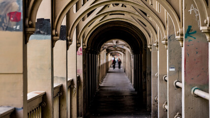 Pedestrians walking on the covered walkway of the High Level Bridge in Newcastle upon Tyne