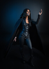  portrait of mysterious hooded woman in black cloak,  gothic fantasy or dystopian character. posing with gestural magical hand poses.  lit with moody shadows, studio scene on dark isolated background