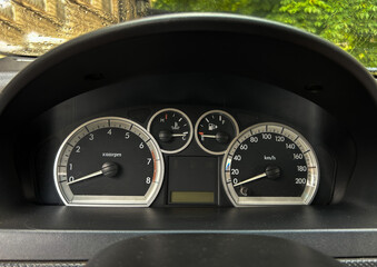 Close-up view of a car dashboard instrument cluster showing tachometer, speedometer, fuel gauge,...