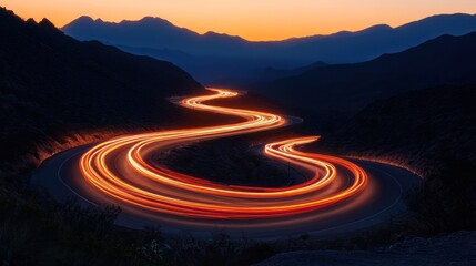 Winding mountain road at sunset, car light trails
