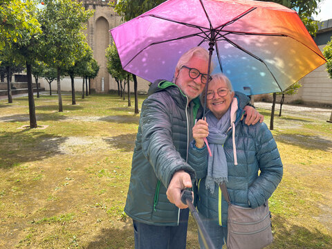 Smiling senior couple takes a selfie together in the garden of a historic house out of Seville during a sightseeing trip enjoying the culture and the pleasant retirement lifestyle