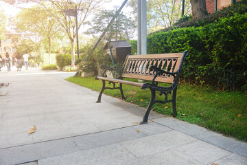 An outdoor chair is placed along the footpath. Cast iron bench. 