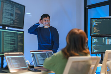 young Asian software development manager leads a late-night office discussion with his executive...