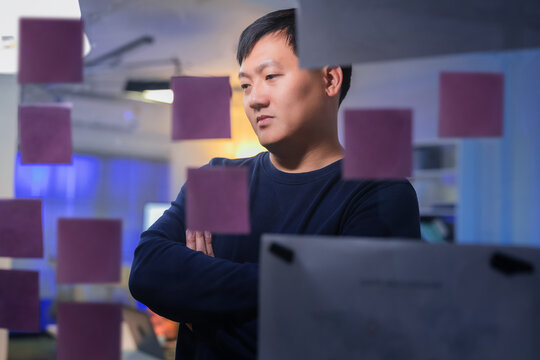 Business team stands around a flip chart, brainstorming app structure and workflow, sharing ideas, mapping flowcharts, and creating an inclusive, hands-on experience in a collaborative meeting