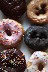 A top down view of many colorful donuts.