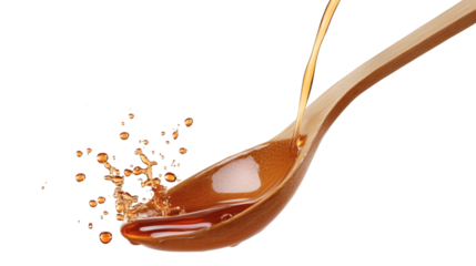 Stream of golden maple syrup pouring from wooden spoon isolated on transparent background 