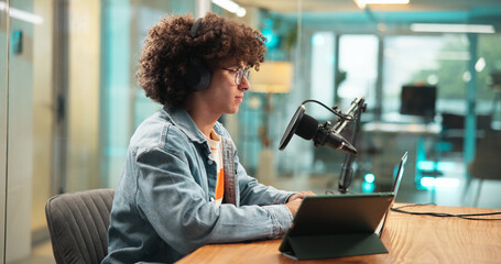 Laptop, headphones and man with microphone for broadcast, podcast and radio host. Computer, reading...