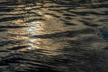light and ripples on the water with texture of the movement of the waves warm colors