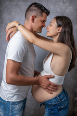 A man hugs his partner who is ninth month pregnant