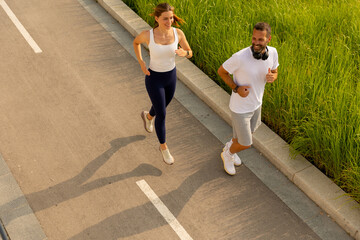 Joyful morning joggers enjoying the sunshine along a scenic pathway surrounded by green grass and vibrant nature
