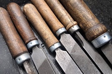 Metal files with wooden handles. Old workshop tools. Vintage carpentry equipment. Rustic background flatlay. Manual steel instruments.