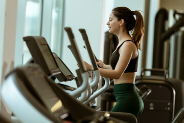 Fitness journey unfolds with determination during cardio workout at modern gym facility