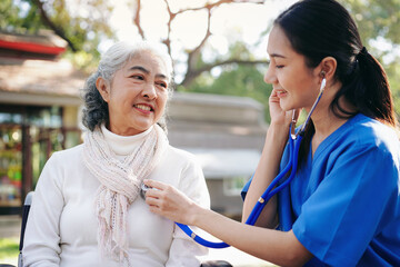 A woman in a blue uniform is checking a woman's heart