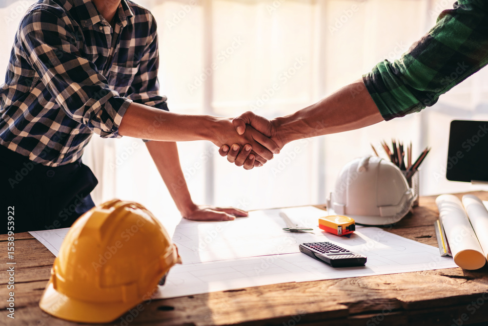 Poster two men shake hands in front of a desk with a calculator, a ruler