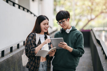 A young man and woman are looking at a tablet together