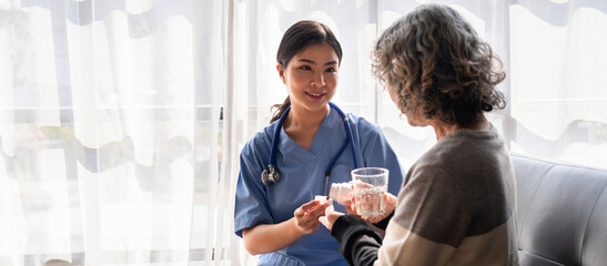 Asian Nurse Helping Older Patient Take Medication with Water Glass Doctor Giving Pills Medical Care at Home Healthcare Support