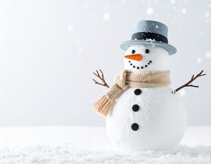 Obraz premium Snowman wearing a blue top hat and beige scarf stands on snowy ground. Snowflakes fall softly in the bright winter landscape.