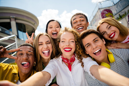 Group of cheerful young friends enjoying a day together outdoors in an urban setting, laughing and bonding over good times
