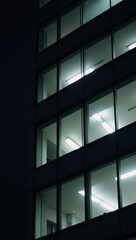 Illuminated office building with dark night texture emphasizing its windows