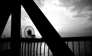 Basra, Iraq - June 19, 2025: A Ferris wheel silhouette against a cloudy, dramatic sky.

