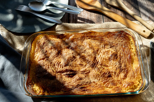 Glass platter with a meat or shepherd's pie on a rustic country table. - Powered by Adobe